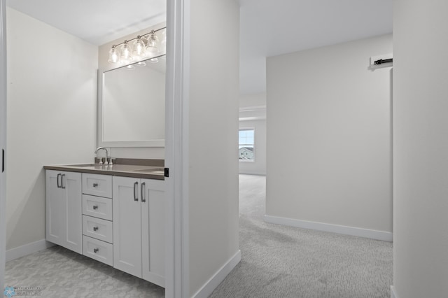 bathroom featuring carpet floors, baseboards, and vanity