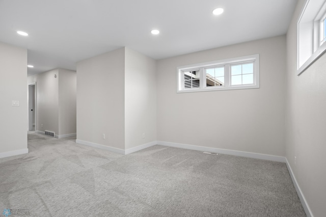 unfurnished room with light carpet, baseboards, visible vents, and recessed lighting