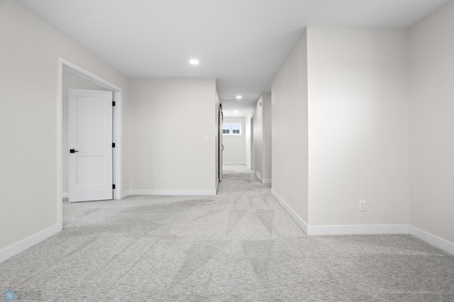 spare room with light carpet, baseboards, and recessed lighting