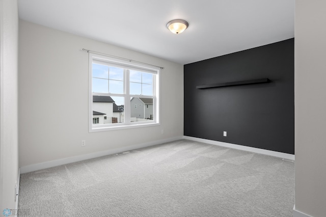 carpeted empty room featuring visible vents and baseboards