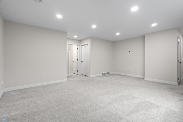 below grade area featuring baseboards, recessed lighting, visible vents, and light colored carpet