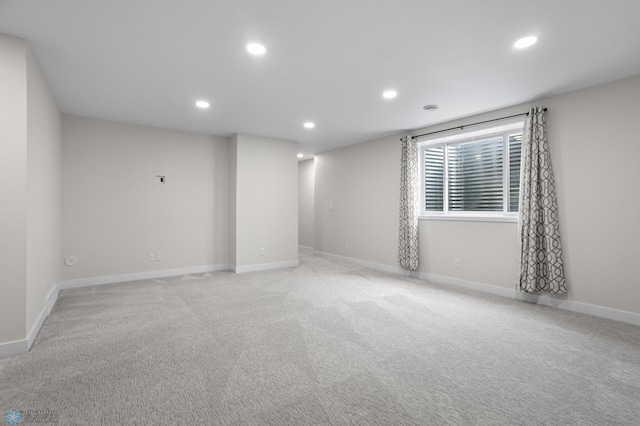 empty room featuring recessed lighting, light carpet, and baseboards