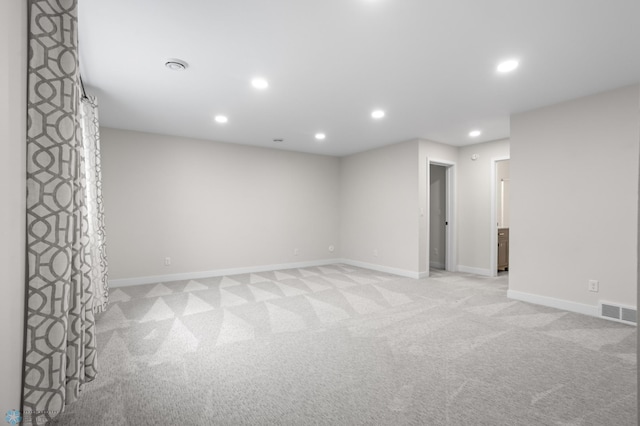 spare room featuring baseboards, recessed lighting, visible vents, and light colored carpet