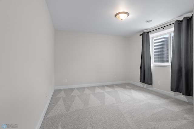 empty room with light carpet and baseboards