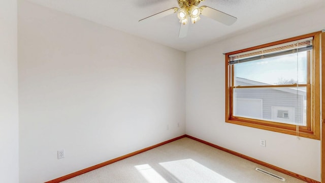 unfurnished room featuring visible vents, light carpet, baseboards, and ceiling fan