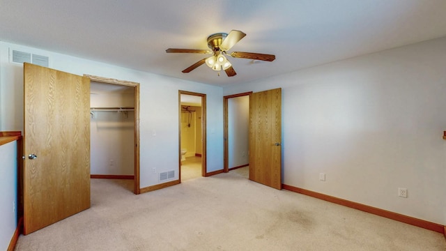 unfurnished bedroom featuring a walk in closet, baseboards, visible vents, and carpet floors