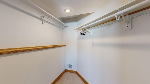 spacious closet with visible vents and carpet floors