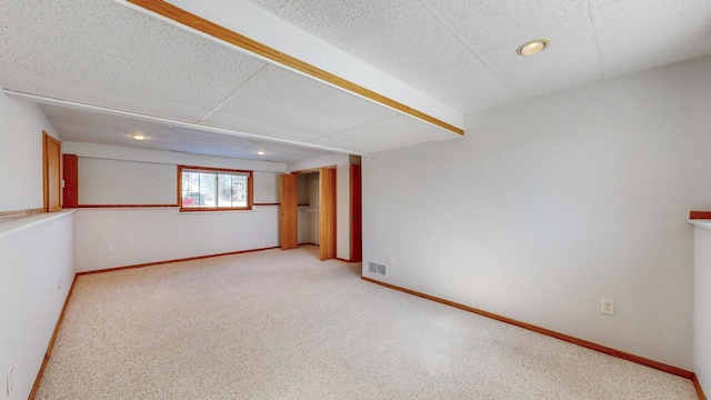 unfurnished room featuring carpet flooring, baseboards, visible vents, and a paneled ceiling