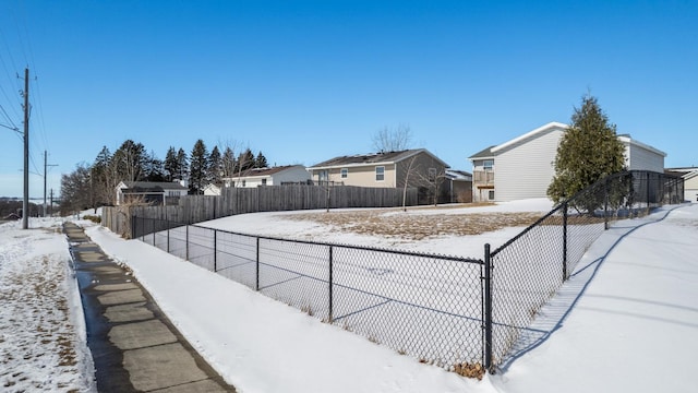 yard covered in snow with fence private yard and a residential view