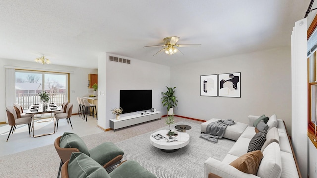 living room featuring visible vents, baseboards, carpet floors, and a ceiling fan