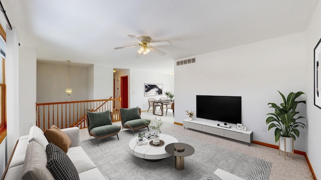 living room featuring a ceiling fan, visible vents, and baseboards