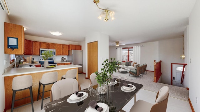 dining area featuring ceiling fan with notable chandelier and baseboards