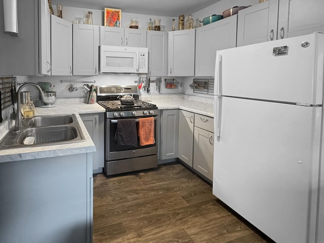6915 11th Ave S, Richfield, MN 55423 - kitchen with white appliances, a sink, light countertops, and dark wood finished floors