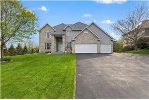 traditional home featuring a front lawn, driveway, and an attached garage