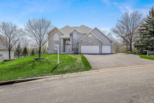 traditional-style house featuring a garage, aphalt driveway, and a front yard