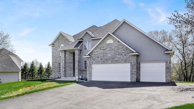 view of front facade featuring a garage, aphalt driveway, brick siding, and stucco siding