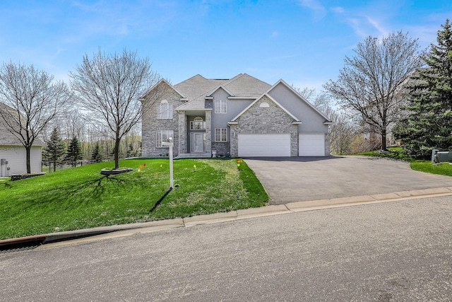 traditional-style home with an attached garage, a front lawn, stone siding, and driveway
