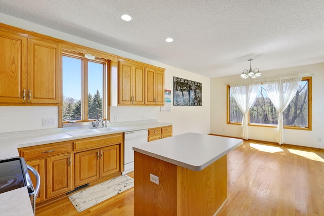 kitchen with a sink, a notable chandelier, range with electric cooktop, a textured ceiling, and white dishwasher