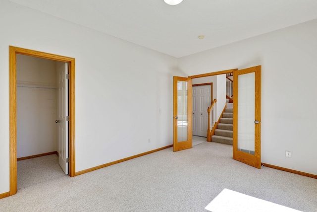 unfurnished bedroom with carpet flooring, baseboards, and french doors