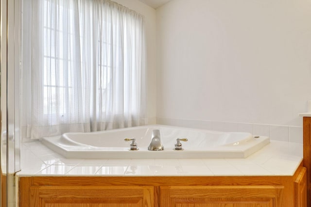 bathroom featuring a garden tub and a healthy amount of sunlight