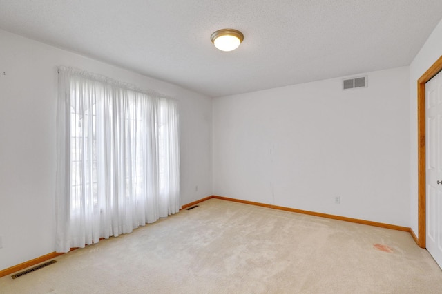 unfurnished room with light carpet and visible vents