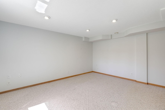 spare room featuring baseboards, light carpet, and recessed lighting