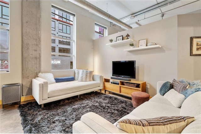 living room with finished concrete flooring and a high ceiling