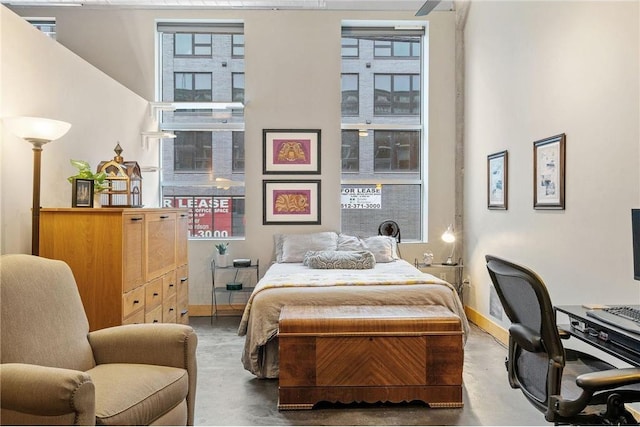 bedroom with finished concrete flooring and baseboards