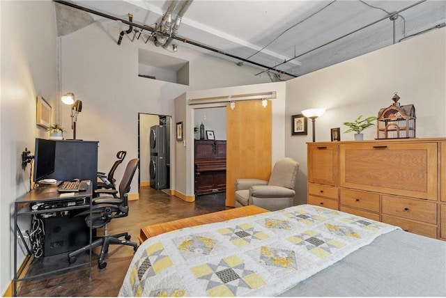 bedroom with a barn door and wood finished floors