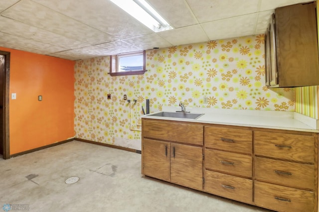 3129 7th St N, Fargo, ND 58102 - kitchen with wallpapered walls, a sink, light countertops, brown cabinetry, and baseboards