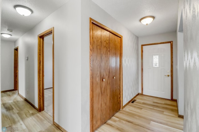 3129 7th St N, Fargo, ND 58102 - corridor featuring light wood-style flooring, a textured ceiling, and baseboards