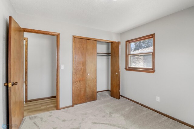 3129 7th St N, Fargo, ND 58102 - unfurnished bedroom with a closet, baseboards, and light colored carpet