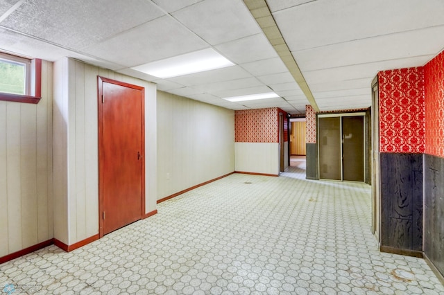 3129 7th St N, Fargo, ND 58102 - basement featuring baseboards, wooden walls, and a drop ceiling