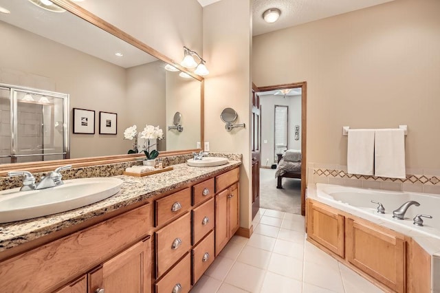 bathroom with tile patterned floors, a sink, a shower stall, and double vanity