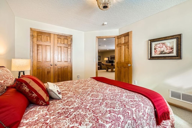 carpeted bedroom featuring a textured ceiling, a closet, and visible vents