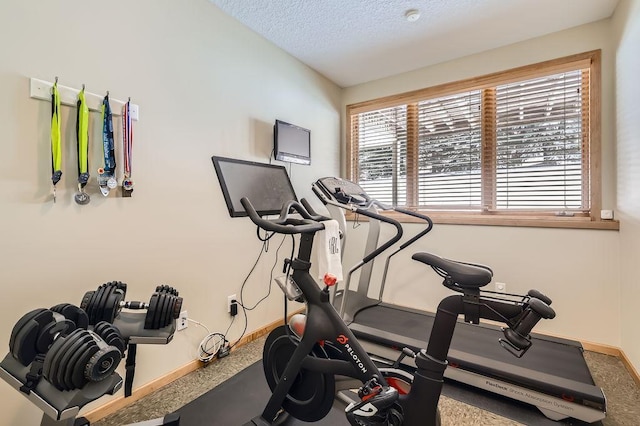 workout area with a textured ceiling and baseboards