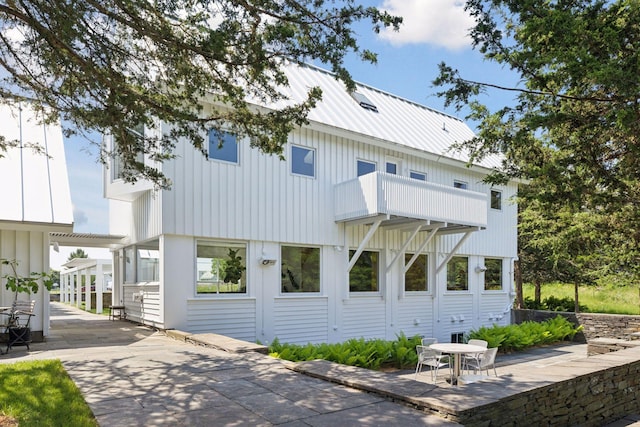 2049 Broadway St, Marine On Saint Croix, MN 55047 - view of front facade featuring a patio area, a metal roof, a balcony, and board and batten siding