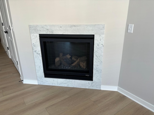 interior details featuring a fireplace, baseboards, and wood finished floors