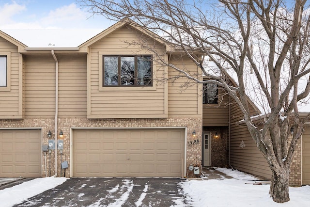 townhome / multi-family property featuring a garage and brick siding