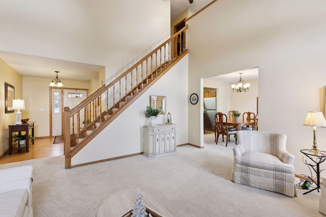 living room featuring stairway, carpet, a chandelier, and baseboards