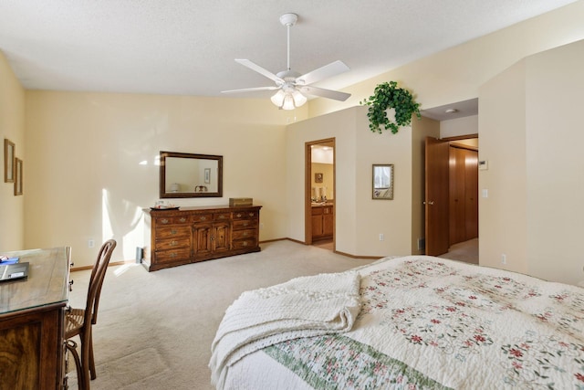 bedroom featuring light carpet, ensuite bath, a ceiling fan, and baseboards