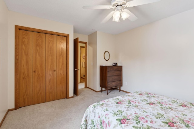 bedroom with a closet, light carpet, ceiling fan, and baseboards