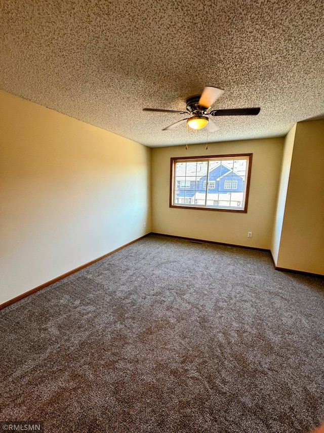 spare room with a textured ceiling, ceiling fan, carpet, and baseboards