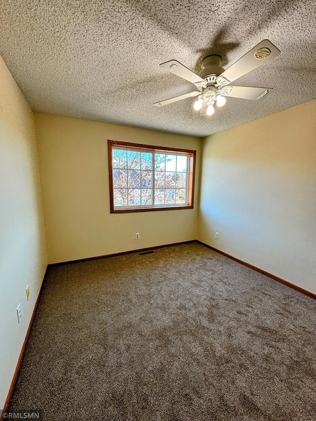 spare room featuring ceiling fan, a textured ceiling, carpet, and baseboards