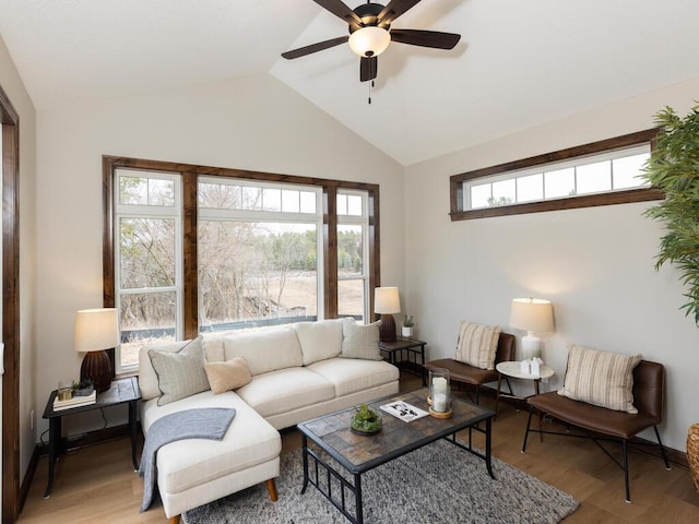 living area featuring vaulted ceiling, ceiling fan, and light wood-style floors