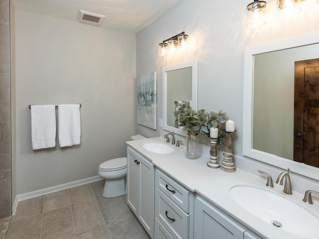 full bath with toilet, double vanity, visible vents, and a sink