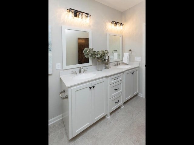 full bathroom with tile patterned floors, a sink, baseboards, and double vanity