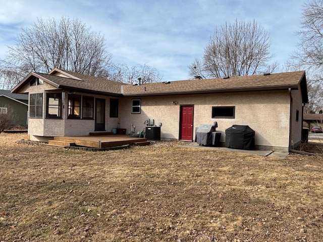 rear view of property with central air condition unit, stucco siding, and a shingled roof