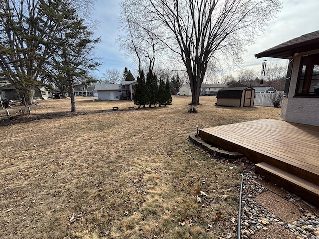 view of yard featuring a deck, an outbuilding, and a storage unit