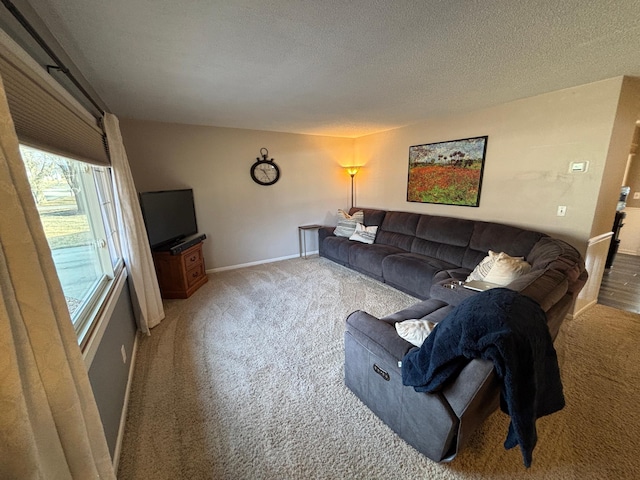 living room featuring baseboards, a textured ceiling, and carpet flooring